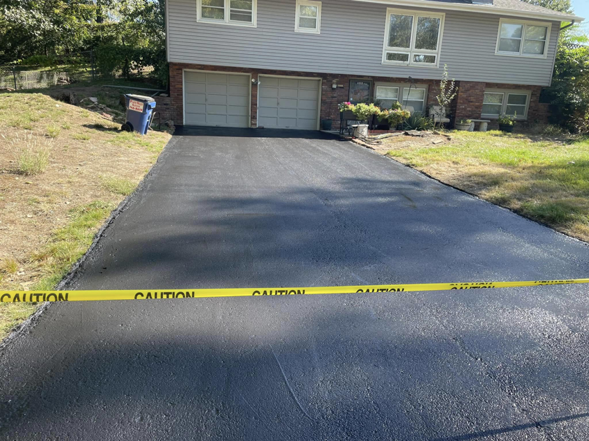 A freshly sealcoated residential asphalt driveway completed by Gorman sealcoating & striping in Blue Springs, MO.