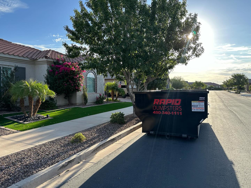 A Rapid Dumpsters container placed on a residential street for junk removal in Chandler, AZ.