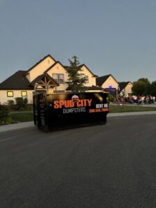 A SpudCity Dumpsters roll-off dumpster placed on a residential street for junk removal in Caldwell, ID.