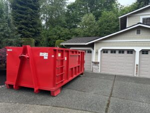 A red dumpster from Cascade Container and Recycling parked in a residential driveway in Seattle, WA.