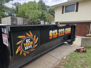 A KC TRASH GUYS LLC dumpster placed on a residential driveway for junk removal in Johnson county, MO.