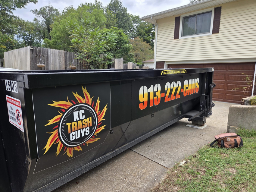 A KC TRASH GUYS LLC dumpster placed on a residential driveway for junk removal in Johnson county, MO.