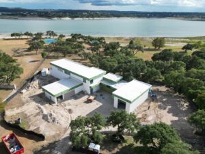 A residential front yard featuring artificial turf, concrete stepping stones, and decorative rocks, installed by Masota Construction in El Paso, TX.