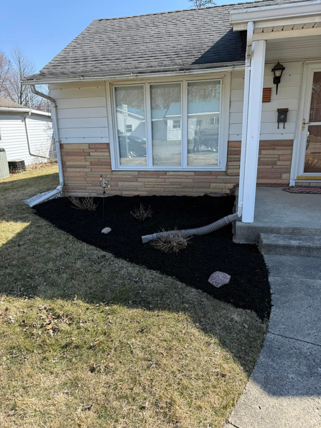 A residential garden bed with fresh dark mulch installed by E&K Property Preservation in Lake, MI.