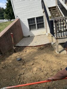 Groundwork being performed next to a residential house with a shovel, indicating a small excavation project by Lankford Dirt Works LLC in Indianapolis, IN.