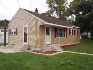 A residential house featuring new siding and red shutters, installed by Bayside Exteriors in Lewes, DE.