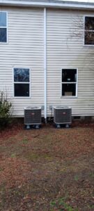 Two outdoor residential HVAC units installed next to a house, showing a service by Pollock HVAC & Electrical in Albany, GA