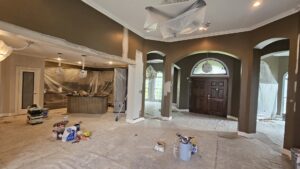 Residential interior painting in progress, with floors covered and walls being painted by Acosta Painting LLC in Jonesboro, AR.