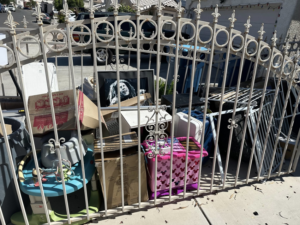A large pile of residential junk and debris behind a decorative gate, ready for removal by S&G Junk Removal Service in Cortlandt Manor, NY.