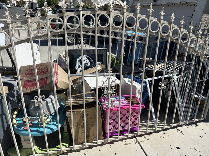 A large pile of residential junk and debris behind a decorative gate, ready for removal by S&G Junk Removal Service in Cortlandt Manor, NY.