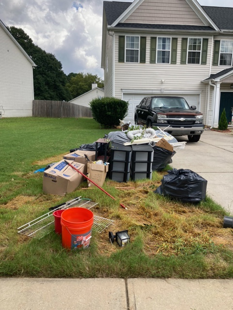 A large pile of residential junk and debris on a driveway, ready for removal by G.I.HAUL ATLANTA in Atlanta, GA.