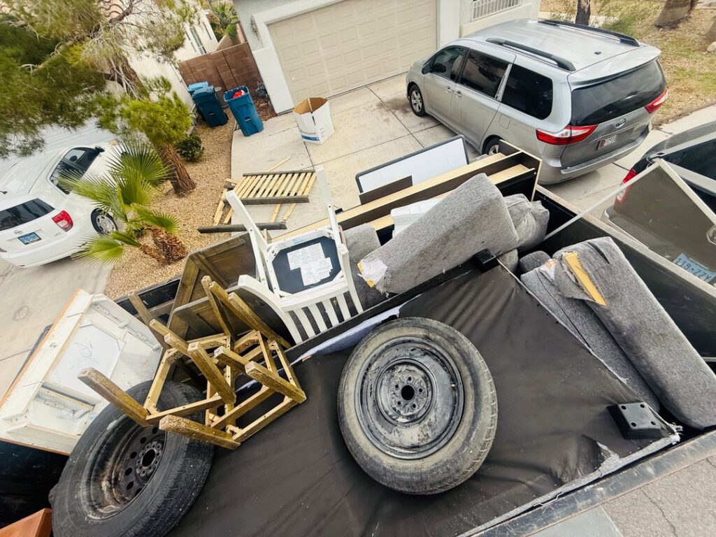 A large pile of residential junk, including a couch and trash bags, placed on the curb for removal by Mike's Dumper in Las Vegas, NV.