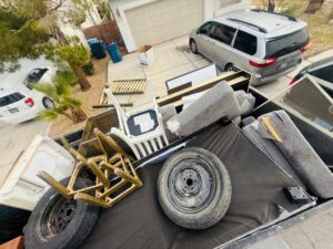 A large pile of residential junk, including a couch and trash bags, placed on the curb for removal by Mike's Dumper in Las Vegas, NV.
