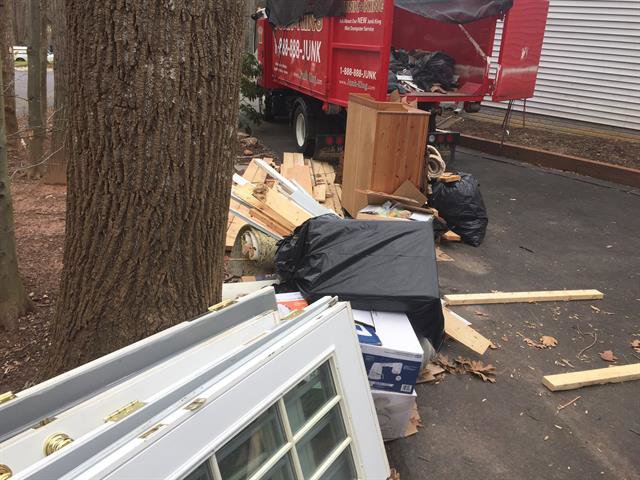 A large pile of residential junk, including doors and bags, awaiting removal by Junk King Plano, TX.