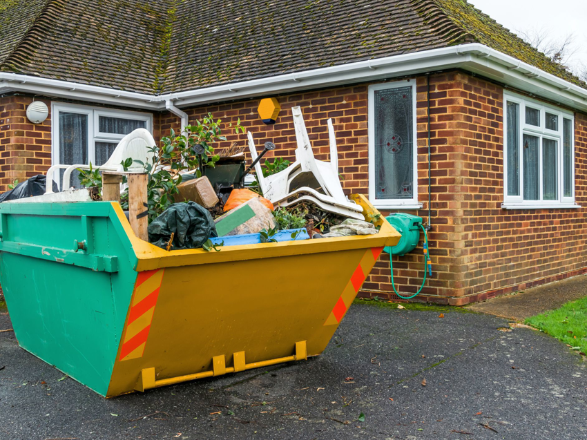 A residential junk removal dumpster filled with debris and old furniture by MAC Containers, Inc in Omaha, NE.