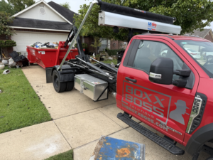 A Boxx Boss Solutions truck and dumpster providing residential junk removal service in Bossier City, LA.