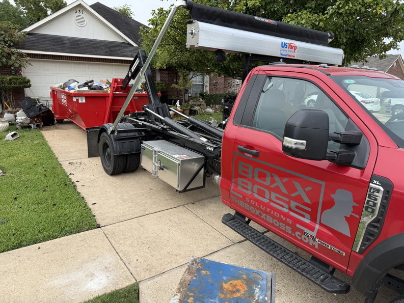 A Boxx Boss Solutions truck and dumpster providing residential junk removal service in Bossier City, LA.