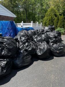A large pile of black trash bags ready for residential junk removal by Green Street Services in Woodbridge Township, NJ.