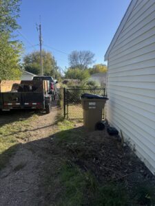 Clean Slate Removal truck and trailer loaded with junk in a residential side yard in Grand Island, NE.