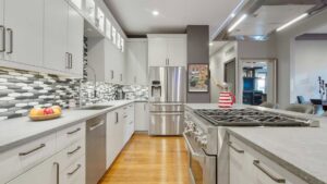 A bright residential kitchen renovation featuring white cabinets and a grey island by ETI Construction in Chicago, IL.