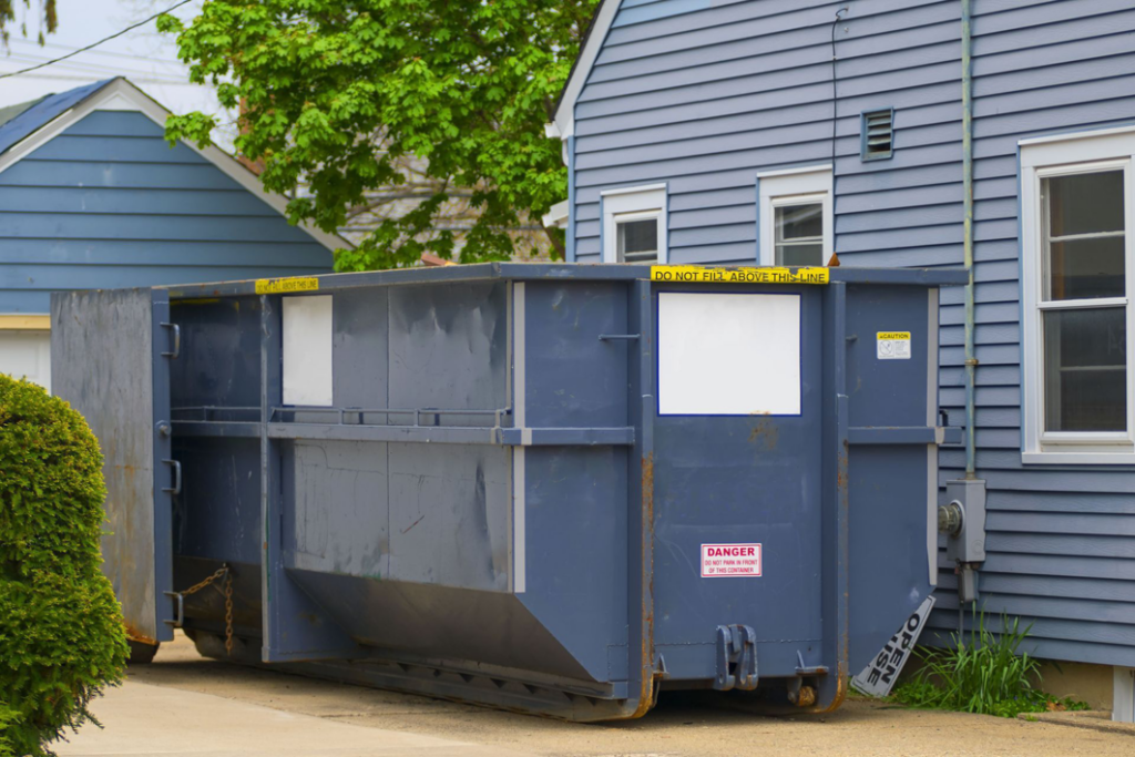 A large blue roll-off dumpster placed for residential junk removal services, typical of jobs in West Fargo, ND.