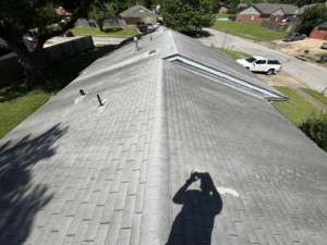 Overview of a residential shingle roof, potentially showing wear or algae growth, inspected by KDB Roofing & Construction in Tulsa, OK