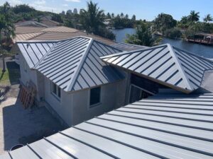 An aerial view of a residential home under construction with a new metal roof installed by Florida Palm Construction, Inc. in Davie, FL