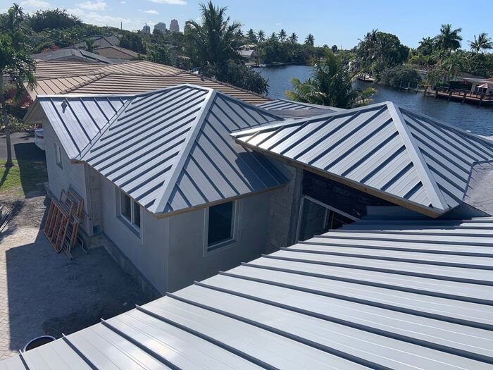 An aerial view of a residential home under construction with a new metal roof installed by Florida Palm Construction, Inc. in Davie, FL