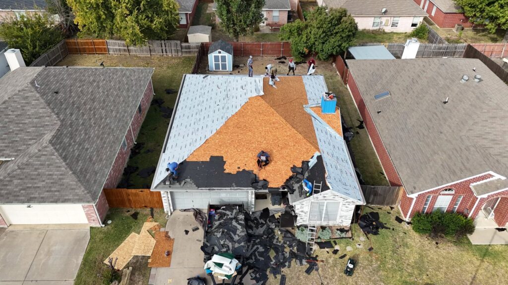 Aerial view of a residential roofing crew working on a roof replacement for Canek Construction LLC in Fort Worth, TX