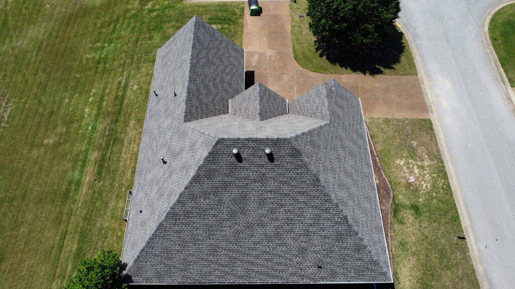 An aerial view of a residential property showcasing a recently completed gray shingle roof by Northcross Restoration Inc in Memphis, TN.
