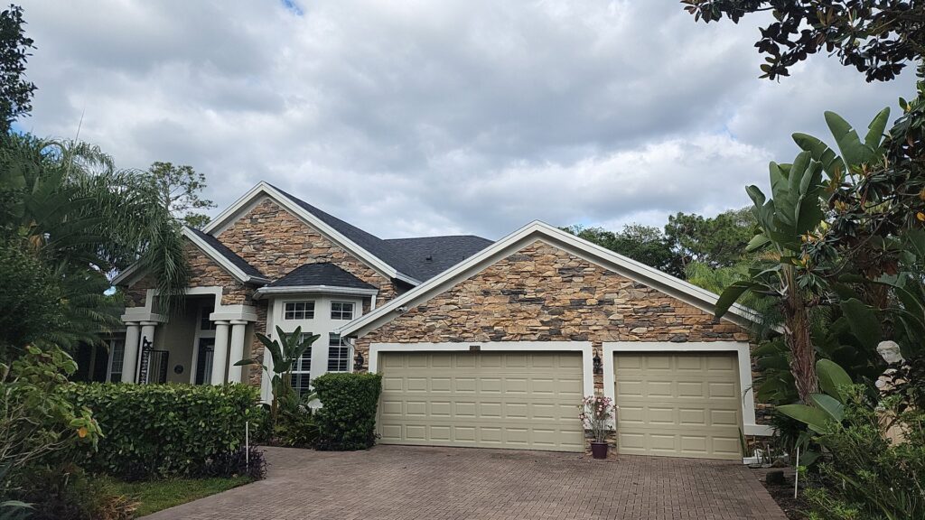 A residential home with a newly completed asphalt shingle roof, a project by Hastings Roofing Service Inc. in Orlando, FL.