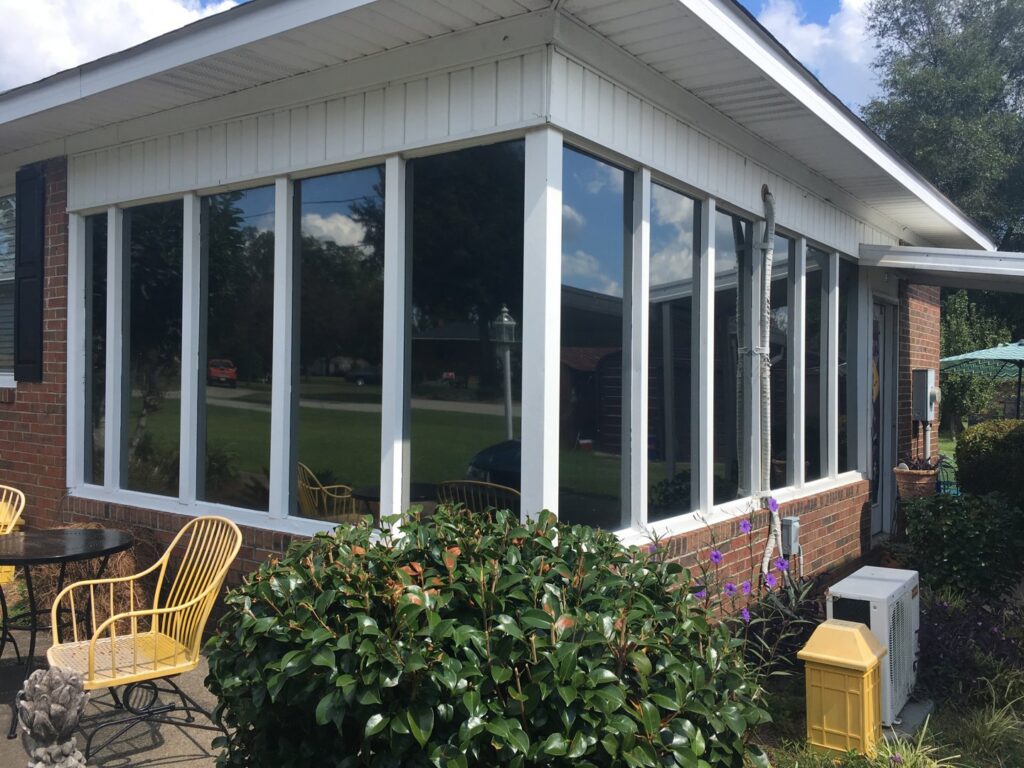 A residential sunroom with large tinted windows, demonstrating UV control services by Augusta Sun & UV Control in Augusta, GA.