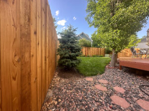 A residential wooden fence installation by GreenView Solutions in Denver, CO, with a stone path.