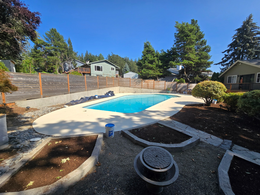 A beautifully resurfaced pool deck and surrounding landscaping after handyman service by Done Right Handy in Wilmington, DE.