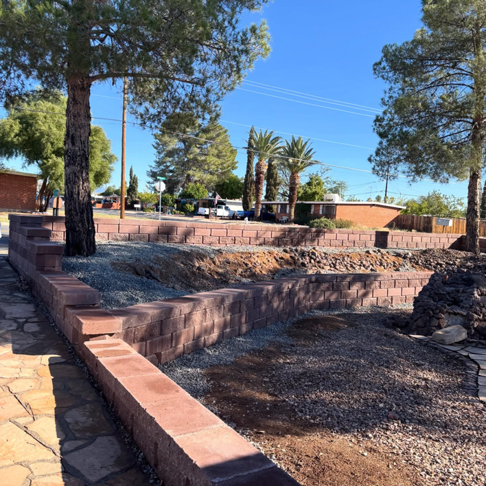 A newly constructed retaining wall made of red blocks by Oakswood Turf and Hardscape in Tucson, AZ