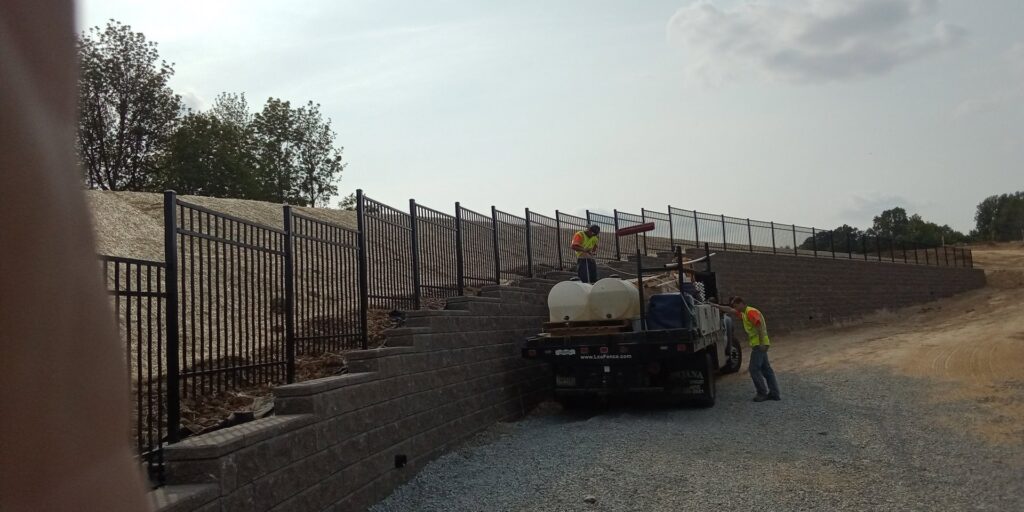 General contractors from Lee Fence and Outdoor constructing a retaining wall and fence at a job site in York, PA.