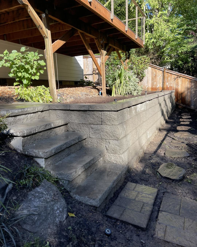 A retaining wall with integrated steps leading to an elevated deck, constructed by MRLM Construction LLC in Beaverton, OR.