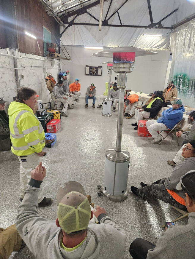 The Ridge Painting, LLC handyman team gathered for a meeting in their Louisville, KY workshop, discussing upcoming projects.