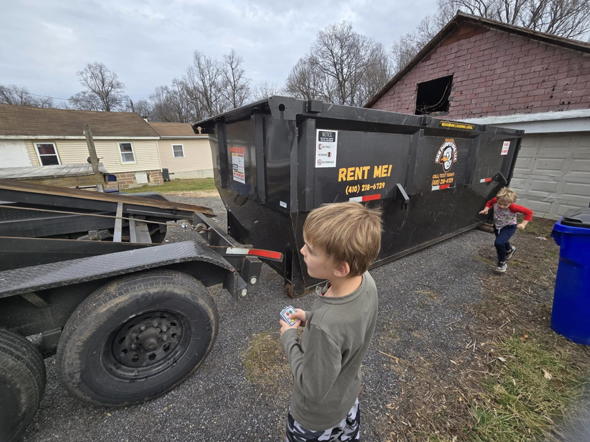 An RKB Dumpsters, LLC roll-off dumpster placed on the ground at a job site in Frederick, MD.