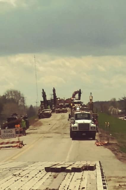 Heavy equipment and trucks working on a road construction project, managed by R A Seaton Contractor Services in Rockford, IL.