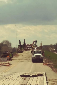 Heavy equipment and trucks working on a road construction project, managed by R A Seaton Contractor Services in Rockford, IL.
