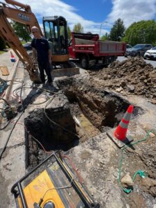 A worker overseeing roadside excavation for plumbing work by JF Plumbing & Heating in Rockville, MD.