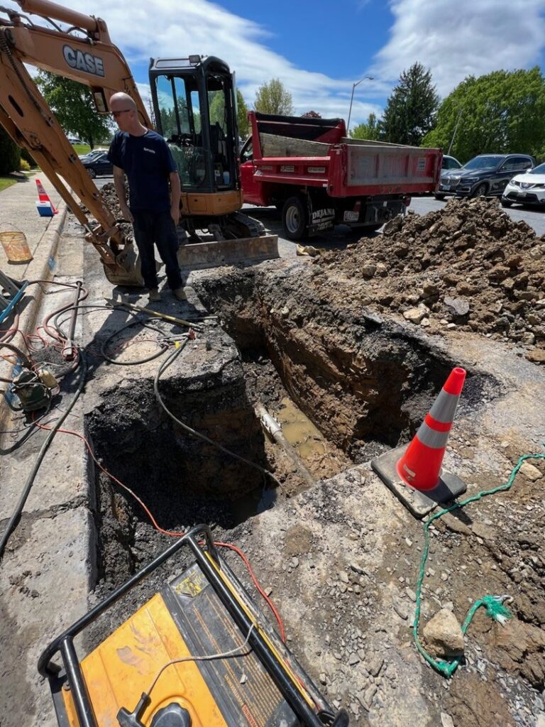 A worker overseeing roadside excavation for plumbing work by JF Plumbing & Heating in Rockville, MD.