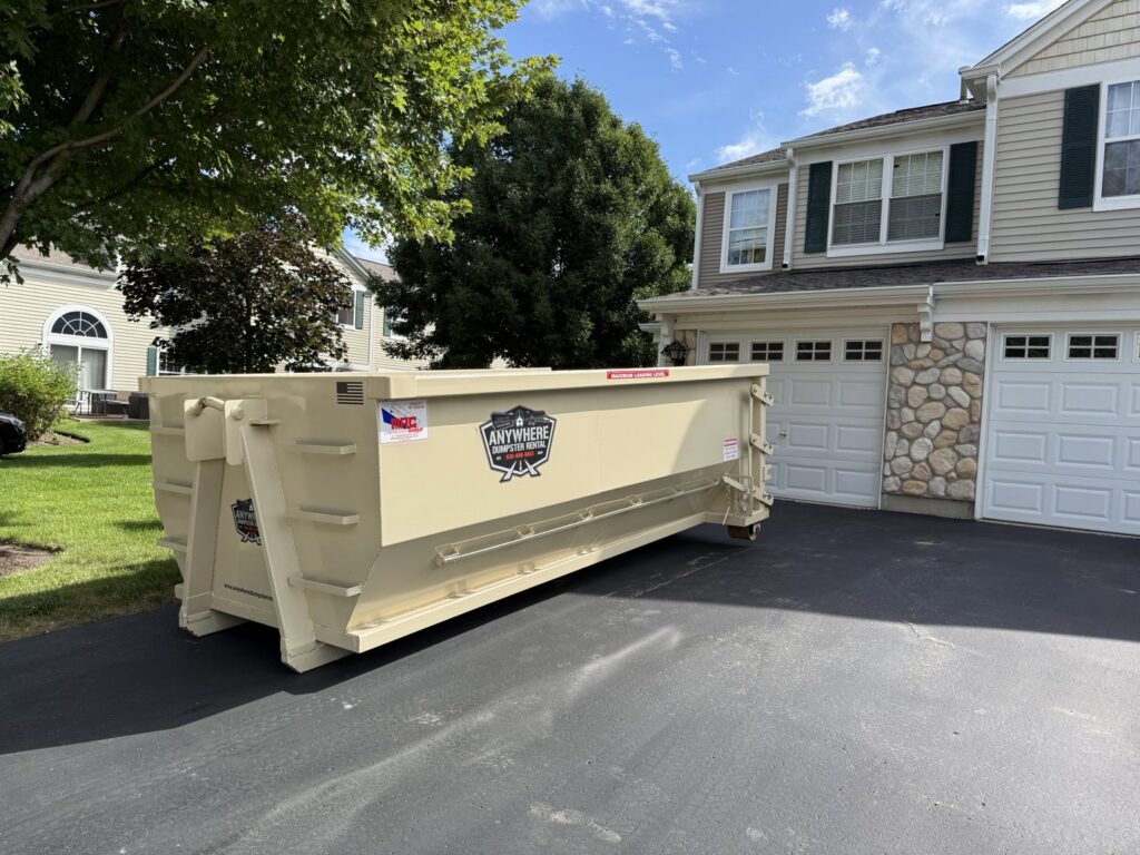 A roll-off dumpster being loaded with junk and debris, demonstrating a junk removal service by Anywhere Dumpster Rental in Naperville, IL.