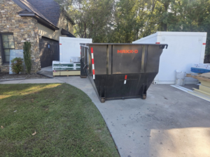 A roll-off dumpster placed at a construction site for debris and junk removal by Hinkins Disposal llc in Augusta, GA.