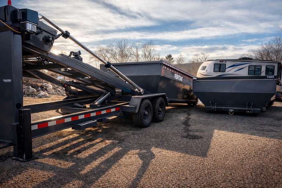 A roll-off dumpster trailer with a dumpster on the ground, ready for junk removal by ClearHouse Hauling in Huron, SD.