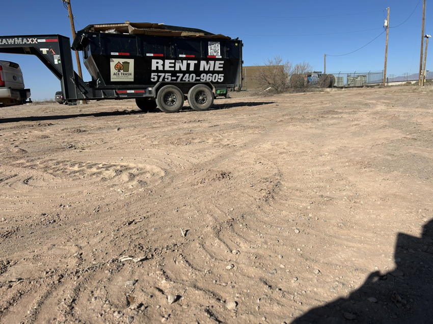 A branded roll-off dumpster trailer from Ace Trash Solutions, filled with cardboard, ready for junk removal in Las Cruces, NM.
