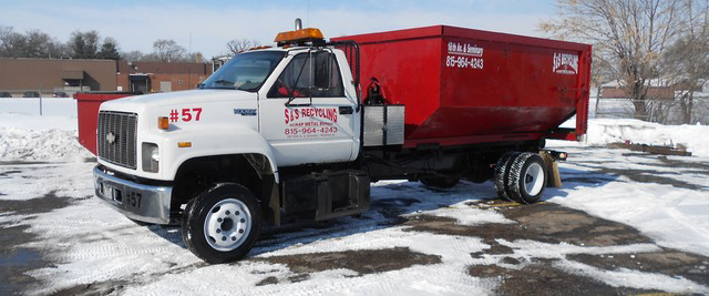 A red roll-off dumpster truck from SS ROLL OFF Dumpsters ready for junk removal service in Rockford, IL.