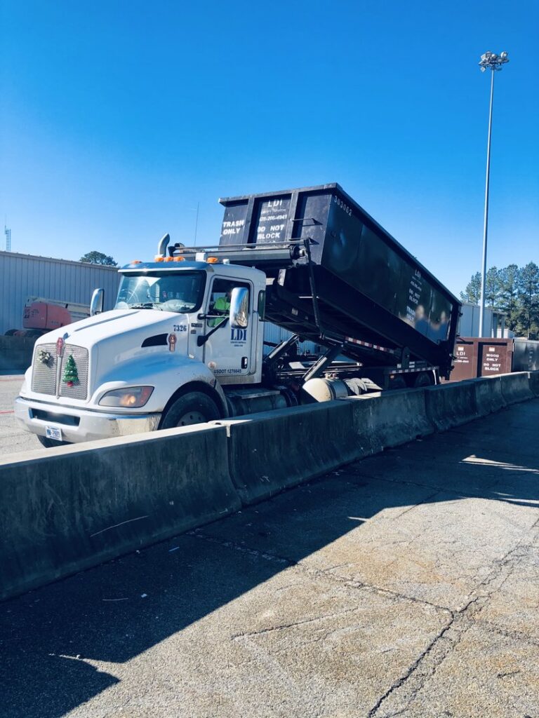 A Liberty Disposal, Inc. roll-off truck with a dumpster at a disposal site in Tucson, AZ.