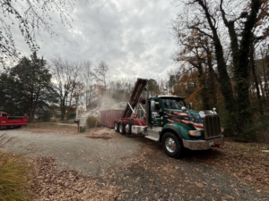 A Patuxent Roll-Off truck collecting a large pile of demolition debris at a job site in Crofton, MD